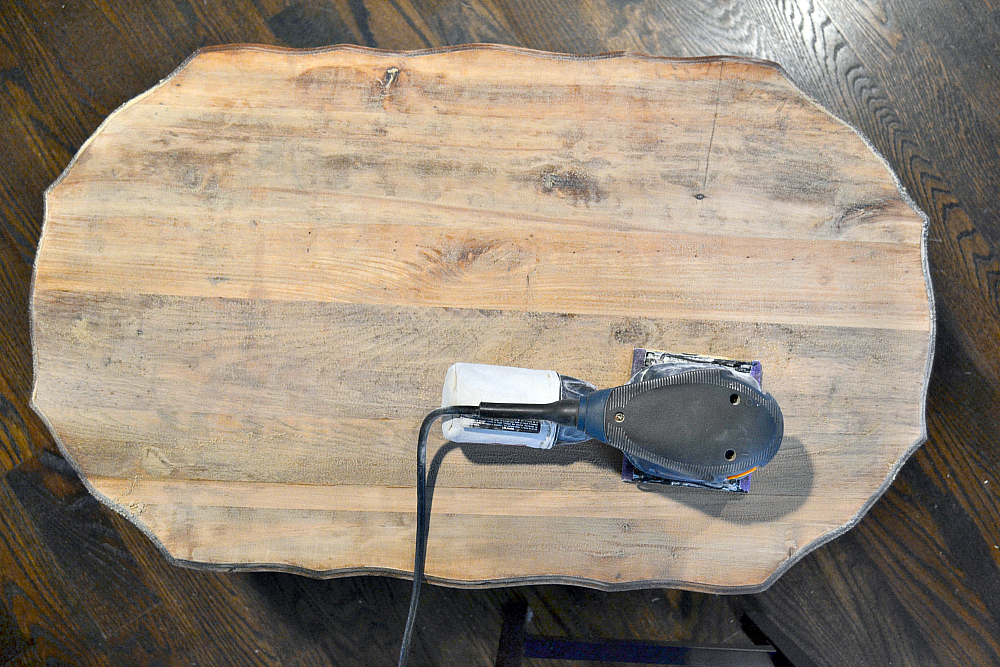 gray side table during the sanding process