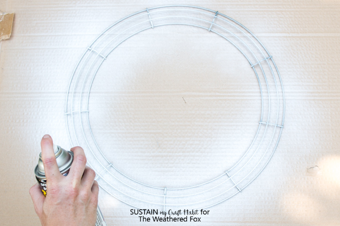 Spray painting a wire wreath frame white